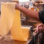 打ち粉を振った台に並べた手打ちパスタの生地